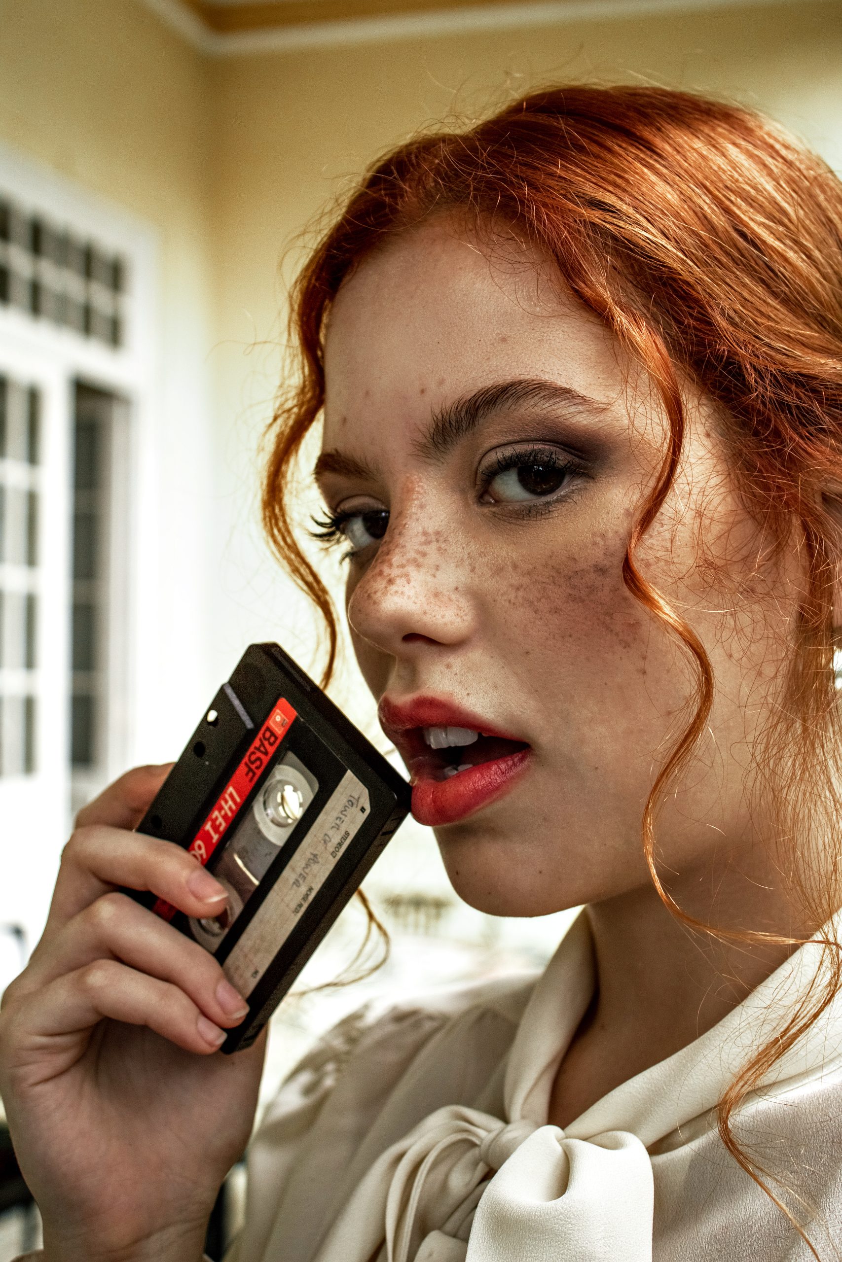 woman holding black and red cassette tape 3912361